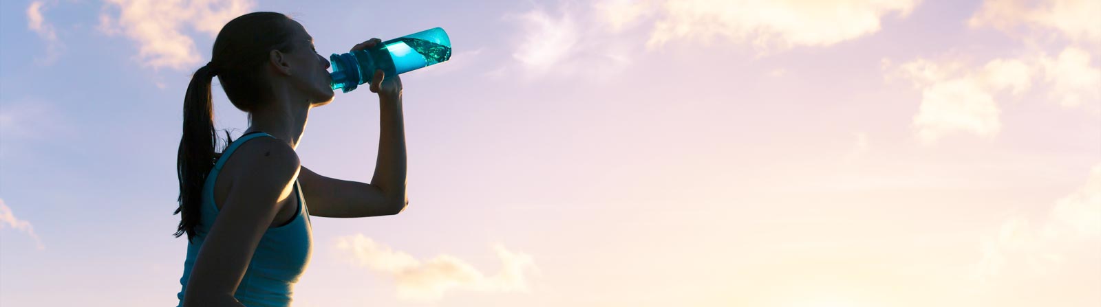 Woman drinking from a sports water bottle.