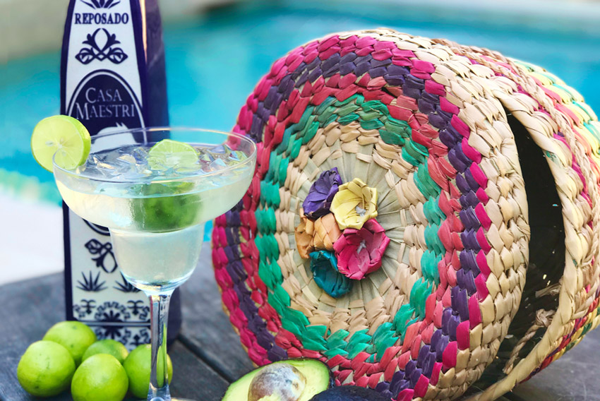 Recipe for a Lime margarita next to a cut avocado.