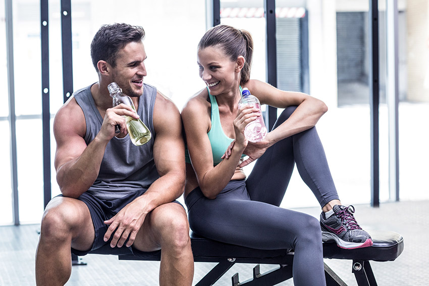 A man and woman drink KSP in a gym.